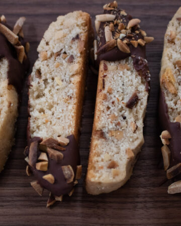 chocolate-dipped mandel bread on wood board