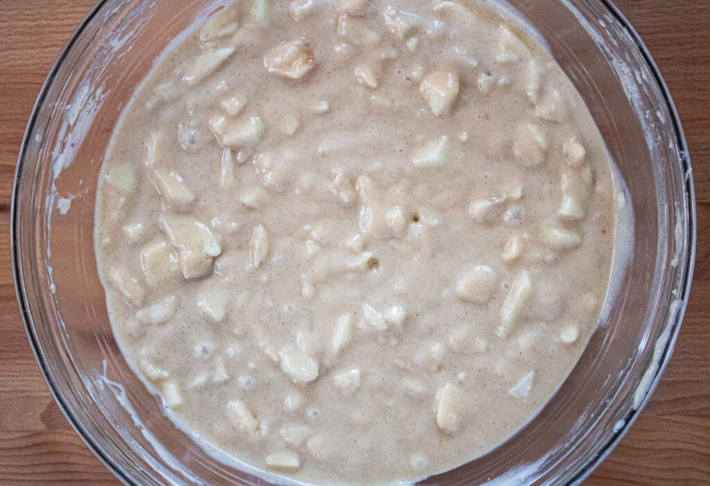 batter in bowl with apples mixed in